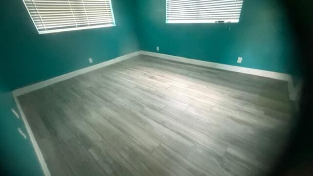 spare room with wood finished floors and baseboards