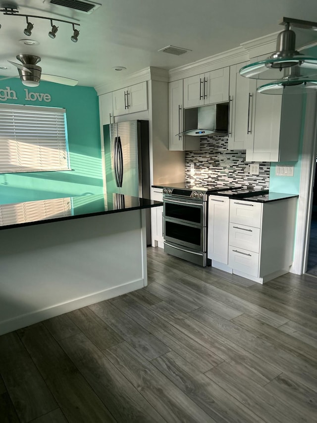 kitchen with dark countertops, tasteful backsplash, stainless steel appliances, and exhaust hood