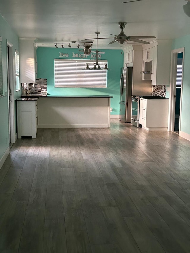 kitchen featuring a peninsula, appliances with stainless steel finishes, dark countertops, and white cabinets