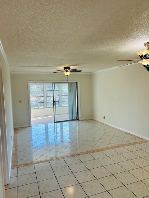 unfurnished room featuring ceiling fan, a textured ceiling, baseboards, and light tile patterned floors