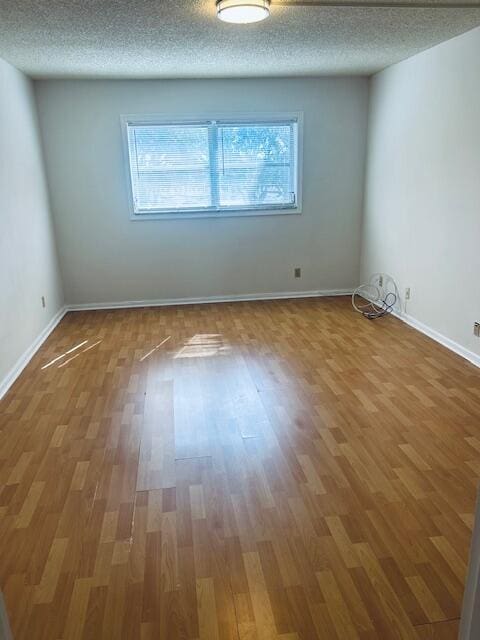 unfurnished room featuring a textured ceiling and wood finished floors