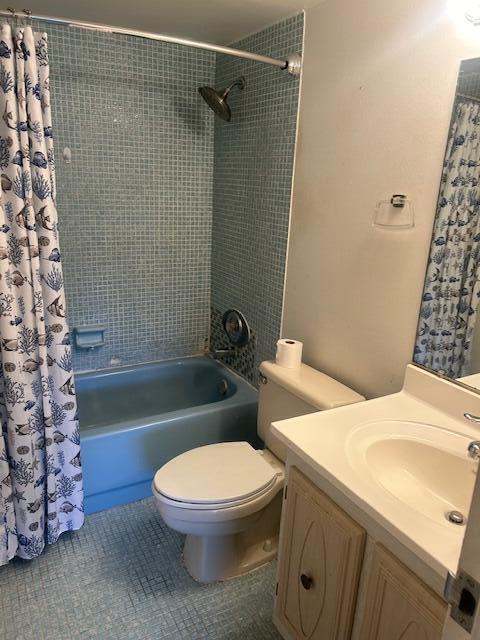 bathroom with shower / bath combination with curtain, tile patterned flooring, vanity, and toilet