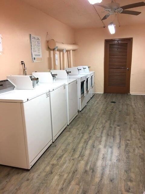 community laundry room with ceiling fan, washer and dryer, and wood finished floors