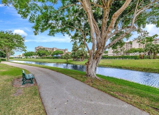 view of community with a lawn and a water view