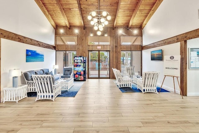 interior space featuring a towering ceiling, light wood finished floors, and beam ceiling