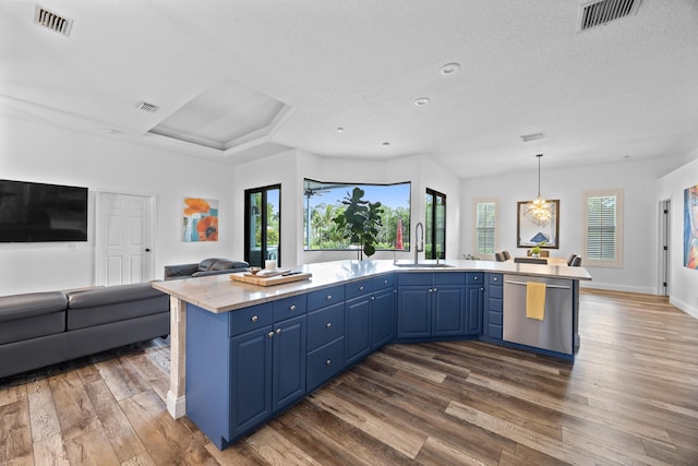 kitchen featuring a kitchen island, open floor plan, light countertops, stainless steel dishwasher, and blue cabinetry