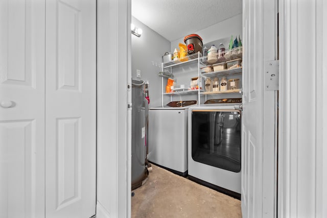 laundry area featuring washing machine and dryer, laundry area, electric water heater, and a textured ceiling