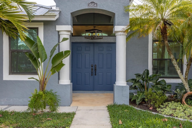 view of exterior entry featuring stucco siding