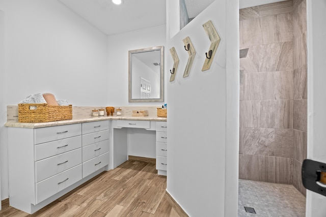 full bath featuring a walk in shower, vanity, and wood finished floors