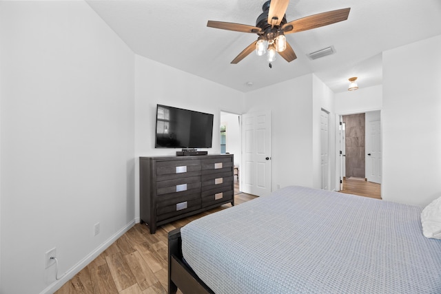 bedroom featuring visible vents, ceiling fan, light wood-style flooring, and baseboards