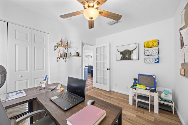 home office with french doors, wood finished floors, a ceiling fan, and baseboards