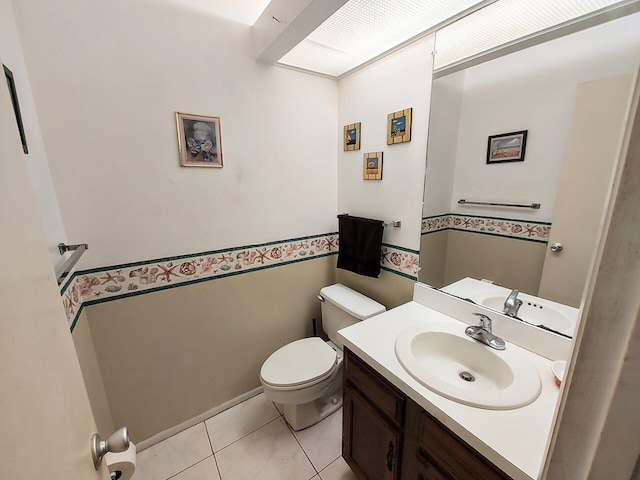 bathroom with toilet, tile patterned flooring, and vanity