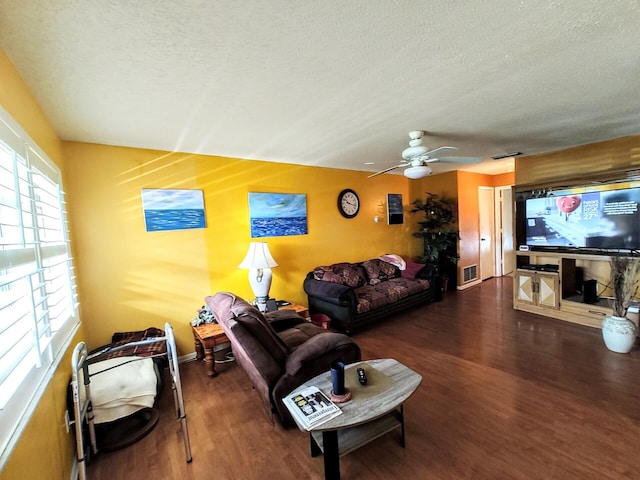 living room featuring visible vents, ceiling fan, a textured ceiling, and wood finished floors