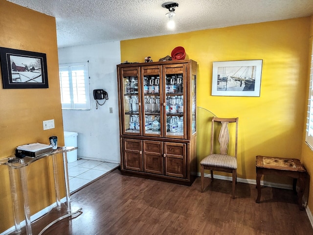 entryway featuring a textured ceiling, baseboards, and wood finished floors