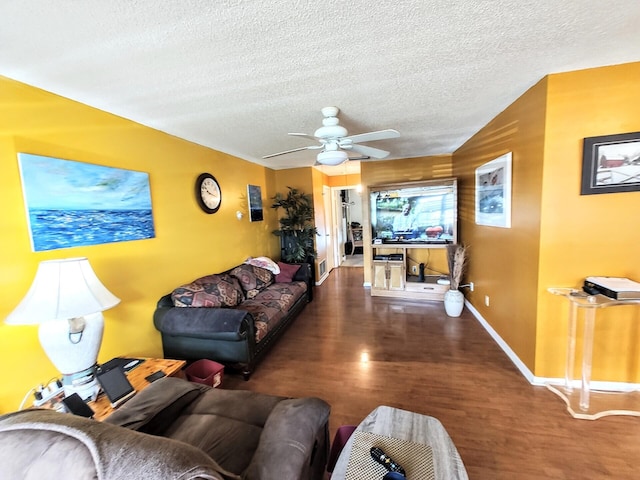 living room with ceiling fan, a textured ceiling, baseboards, and wood finished floors