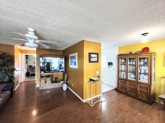 entryway with baseboards, visible vents, ceiling fan, wood finished floors, and a textured ceiling