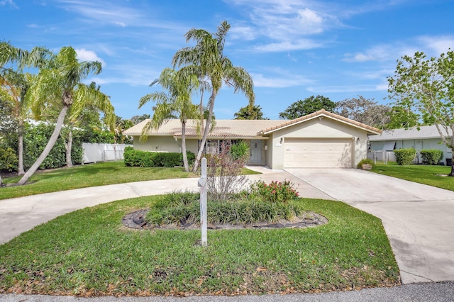 ranch-style house featuring a garage, concrete driveway, fence, a front lawn, and stucco siding