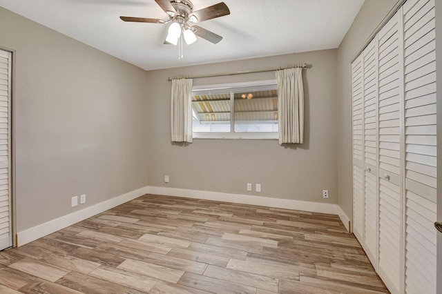 unfurnished bedroom with light wood-style floors, ceiling fan, and baseboards