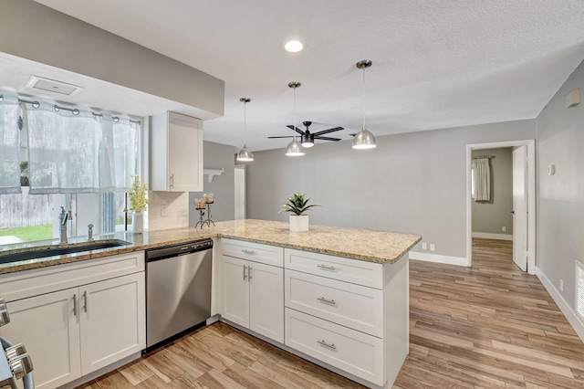 kitchen featuring light wood finished floors, white cabinets, dishwasher, a peninsula, and a sink