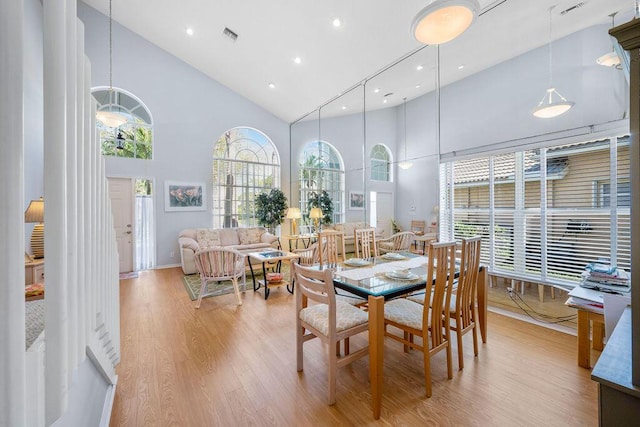 dining space with high vaulted ceiling, recessed lighting, visible vents, and light wood-style floors