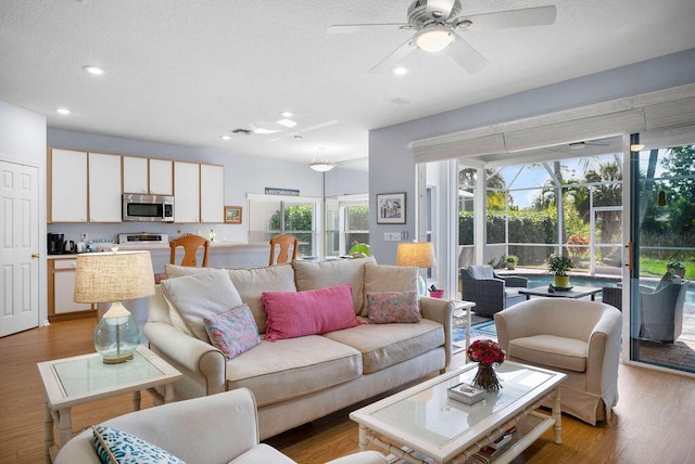 living area featuring recessed lighting, visible vents, a sunroom, ceiling fan, and light wood-type flooring