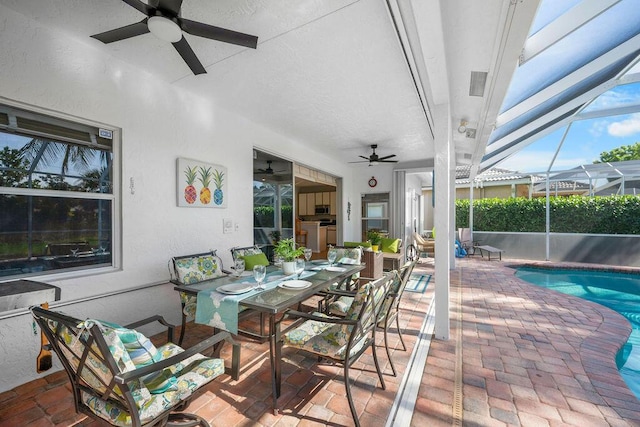 view of patio with a lanai, a fenced in pool, outdoor dining area, and a ceiling fan