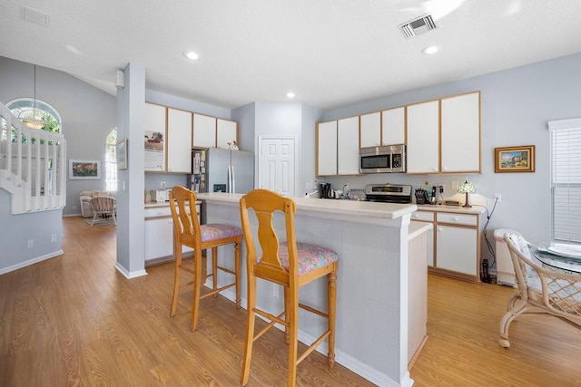 kitchen featuring white cabinetry, visible vents, appliances with stainless steel finishes, and light countertops