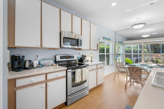 kitchen featuring light countertops, appliances with stainless steel finishes, and white cabinetry