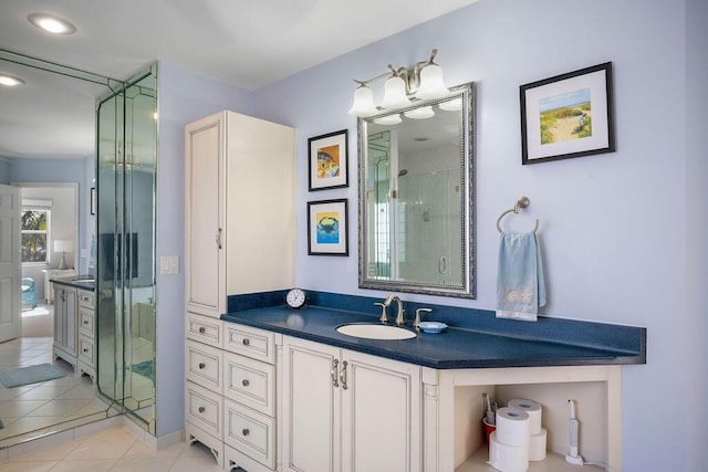 bathroom featuring tile patterned flooring, vanity, and a shower stall