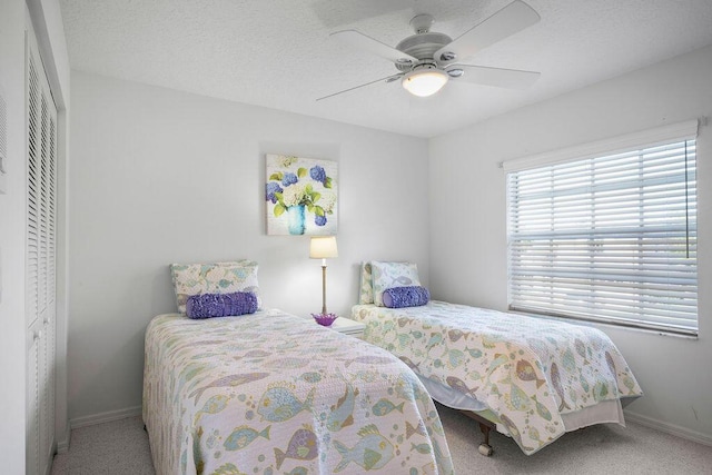 carpeted bedroom featuring ceiling fan, multiple windows, baseboards, and a closet