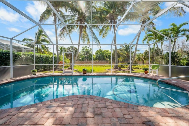 pool with glass enclosure and a patio area