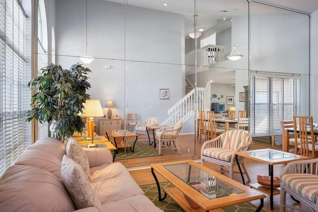 living room with wood finished floors, a high ceiling, and stairs