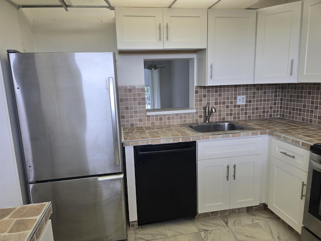 kitchen featuring black dishwasher, white cabinets, and freestanding refrigerator