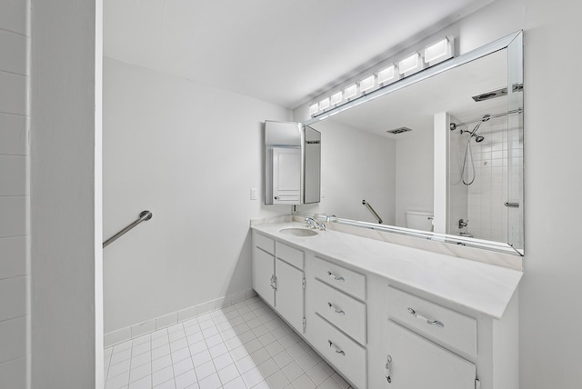 bathroom featuring vanity, baseboards, a tile shower, tile patterned flooring, and toilet