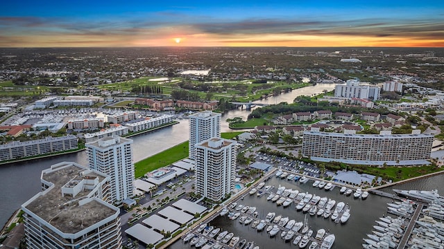 aerial view at dusk featuring a city view and a water view