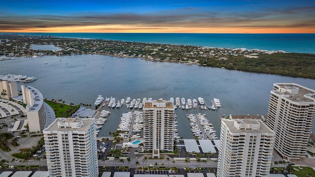 aerial view at dusk featuring a water view and a view of city