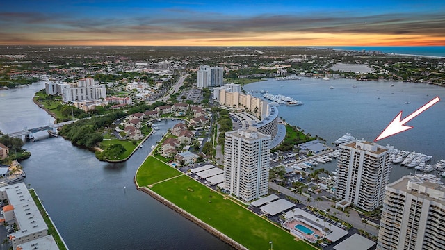 aerial view at dusk with a view of city and a water view