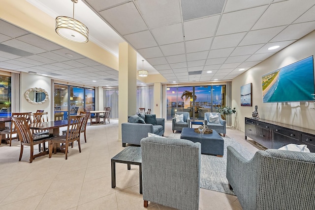living area featuring tile patterned floors, a drop ceiling, recessed lighting, and ornamental molding
