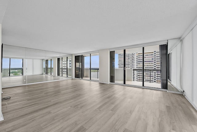 unfurnished living room with floor to ceiling windows and a healthy amount of sunlight