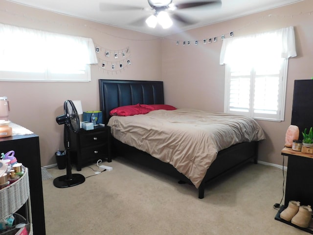 carpeted bedroom with multiple windows and a ceiling fan