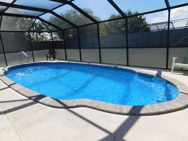 view of pool with a lanai, a patio area, fence, and a fenced in pool