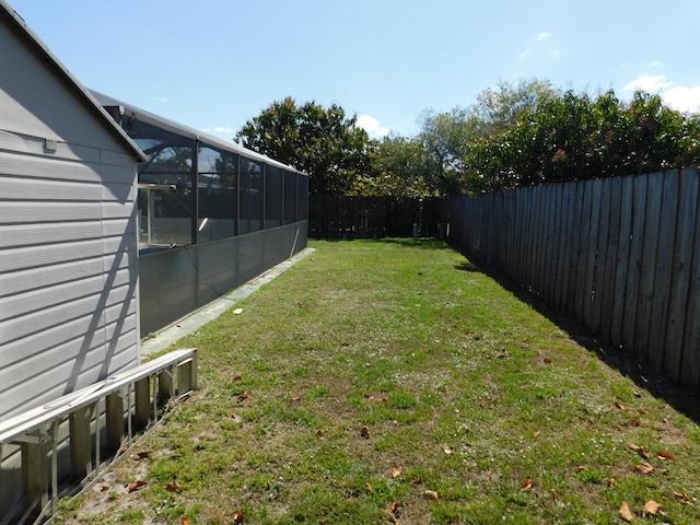 view of yard with a lanai and a fenced backyard