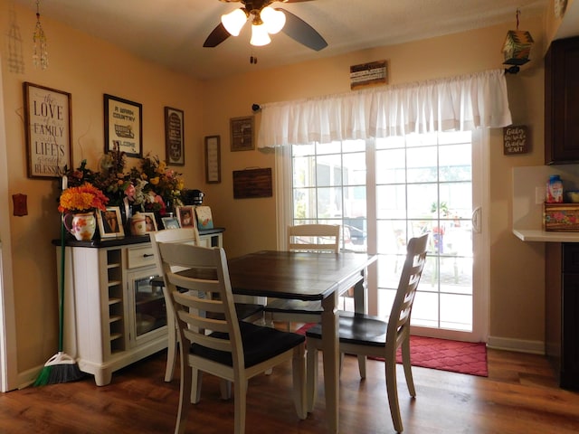 dining area with baseboards, a ceiling fan, and wood finished floors