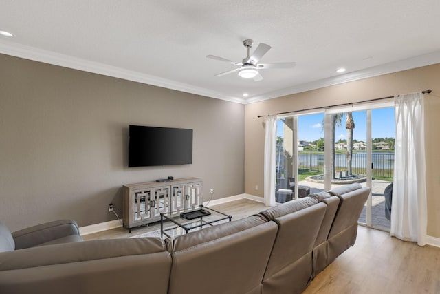 living room featuring ornamental molding, light wood finished floors, and baseboards