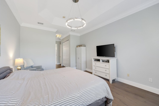 bedroom featuring dark wood-style flooring, visible vents, baseboards, a tray ceiling, and crown molding