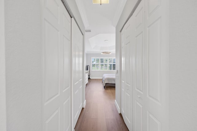 hallway featuring baseboards, dark wood finished floors, crown molding, and a textured wall