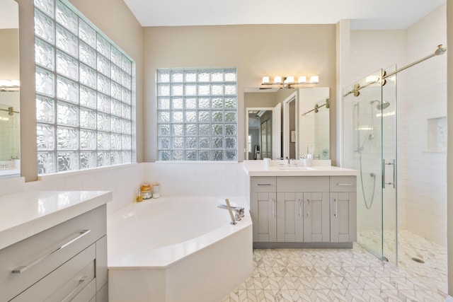 bathroom featuring a stall shower, a bath, and vanity