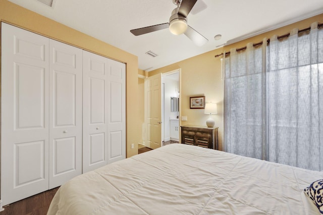 bedroom with dark wood-style floors, a closet, visible vents, and ceiling fan