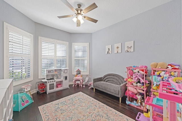 rec room featuring dark wood-style floors, a ceiling fan, and baseboards