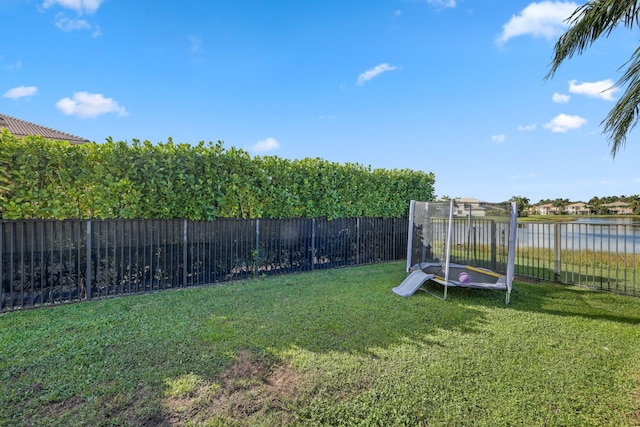 view of yard with a water view and a fenced backyard